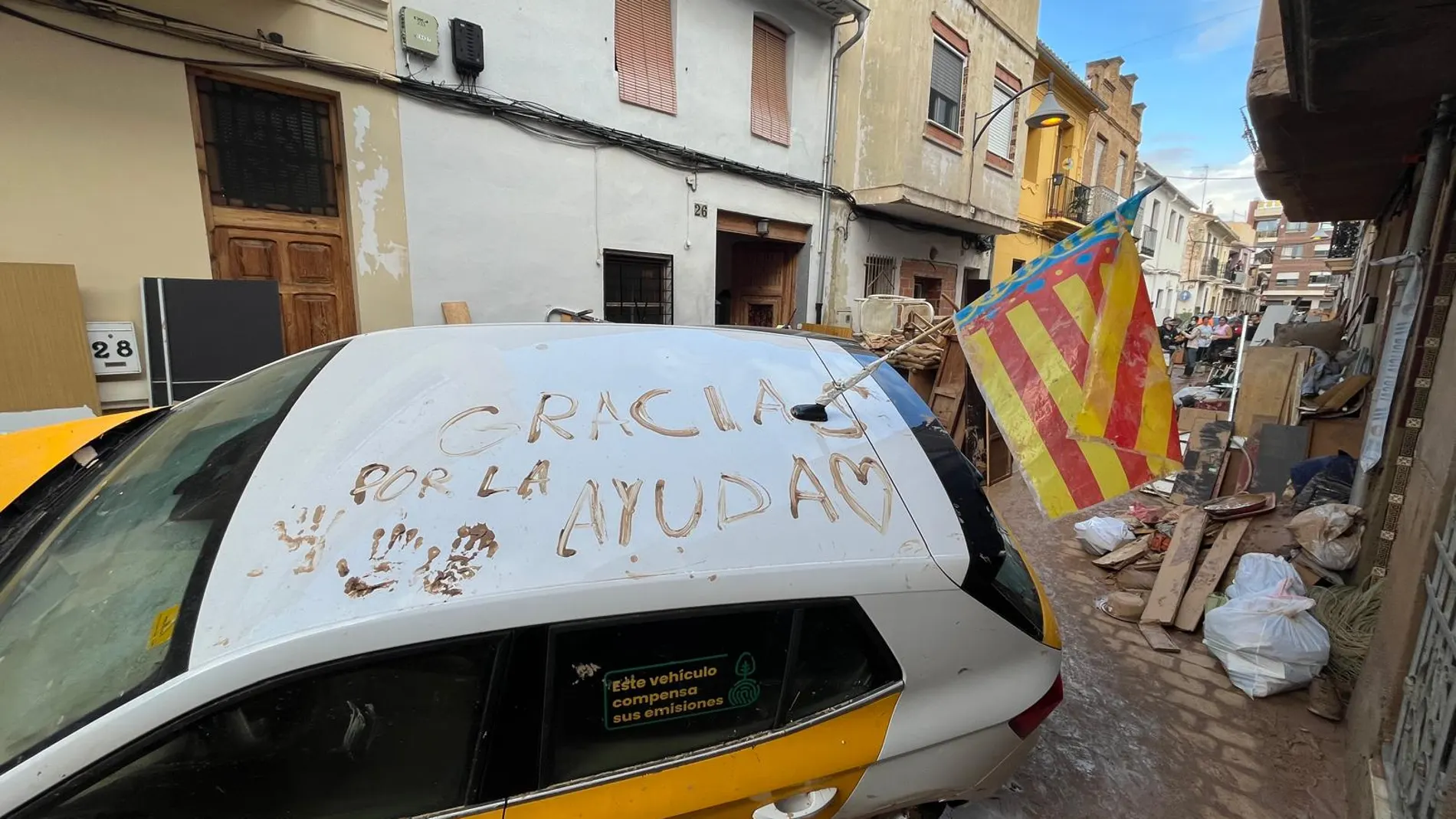 Mensaje en un coche escrito con fango en agradecimiento a los voluntarios