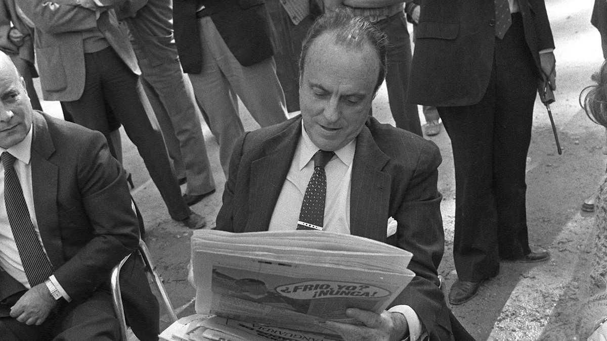 Alicante, 23-10-1982.- Manuel Fraga Iribarne, líder de la coalición electoral AP-PDP, se toma unos minutos de descanso en la agitada campaña electoral para tomar café, leer la prensa y hacerse limpiar los zapatos.