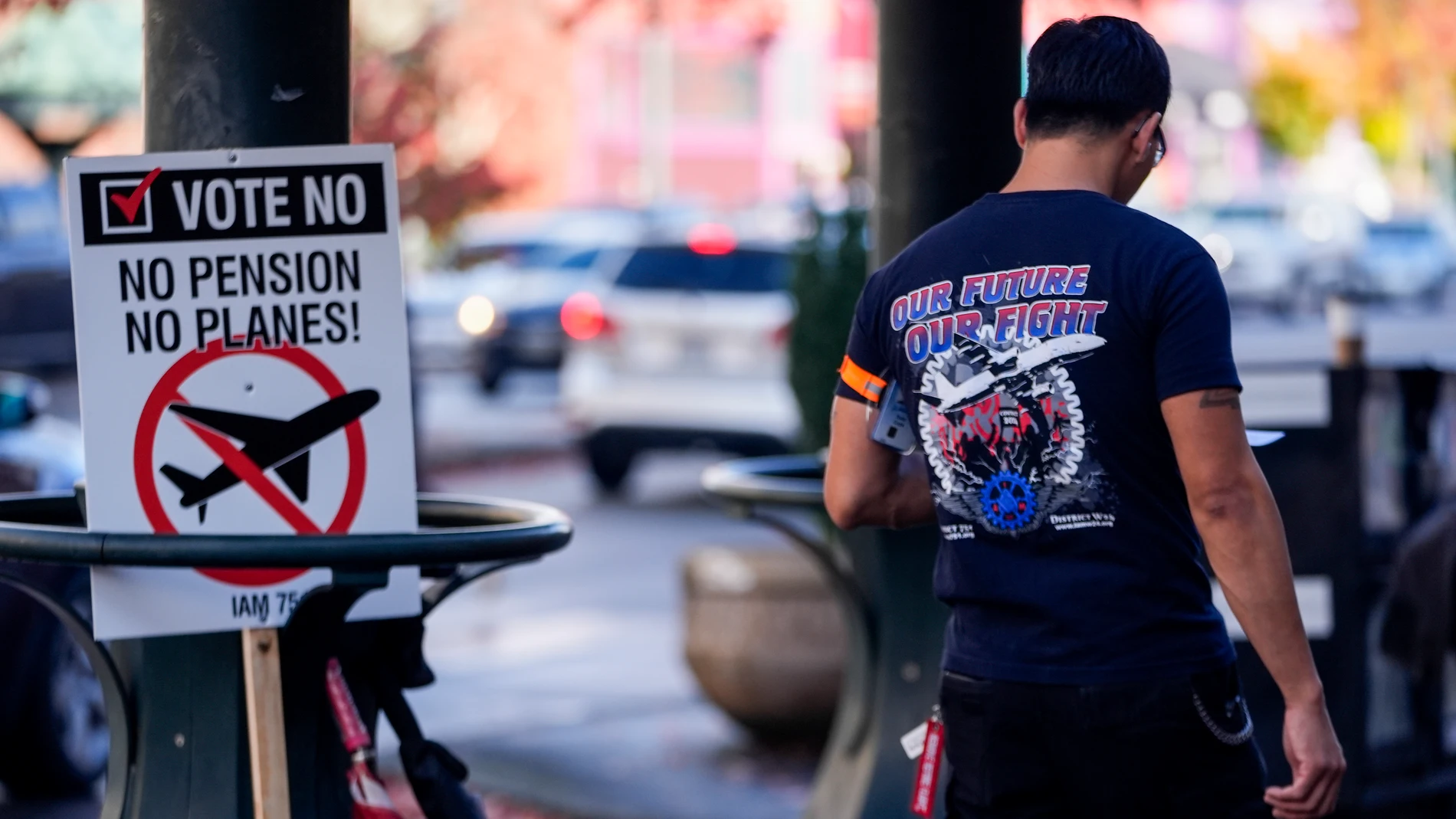 A Boeing employee walks by a picket sign urging people to vote no on a new contract offer from the company, Monday, Nov. 4, 2024, in Everett, Wash. (AP Photo/Lindsey Wasson)