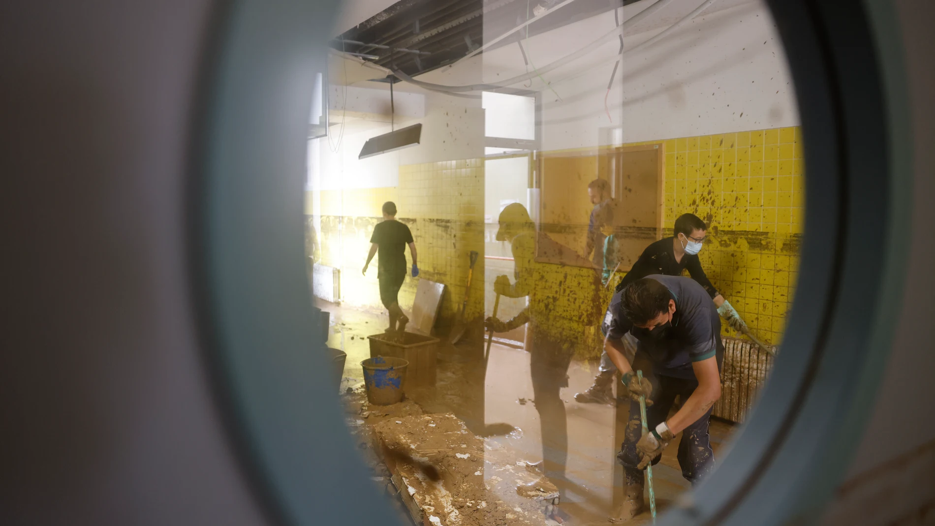 SEDAVÍ (VALENCIA), 04/11/2024.- Varias personas trabajan en las labores de limpieza del lodo en un colegio de Sedaví, Valencia. La provincia de Valencia intenta retomar la actividad laboral y las clases en los colegios mientras continúan de forma intensa las labores de búsqueda de desaparecidos, de abastecimiento y atención a los damnificados, y de la limpieza de las calles y bajos de numerosos municipios, sobre los que ha vuelto a llover este domingo. EFE/Ana Escobar