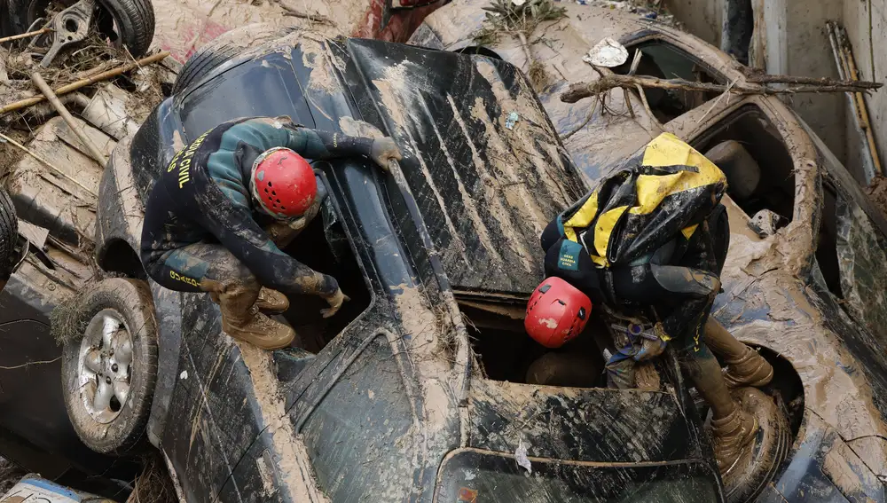 PAIPORTA (VALENCIA), 02/11/2024.- Expertos de la Guardia Civil buscan cuerpos sin vida entre los vehículos atrapados entre los cimientos de un edificio en construcción, este sábado, en Paiporta, Valencia. /