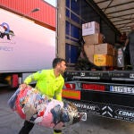 Un voluntario ayuda a llenar uno de los tráiler con ayuda