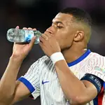 Kylian Mbappé bebe agua durante un encuentro con su selección
