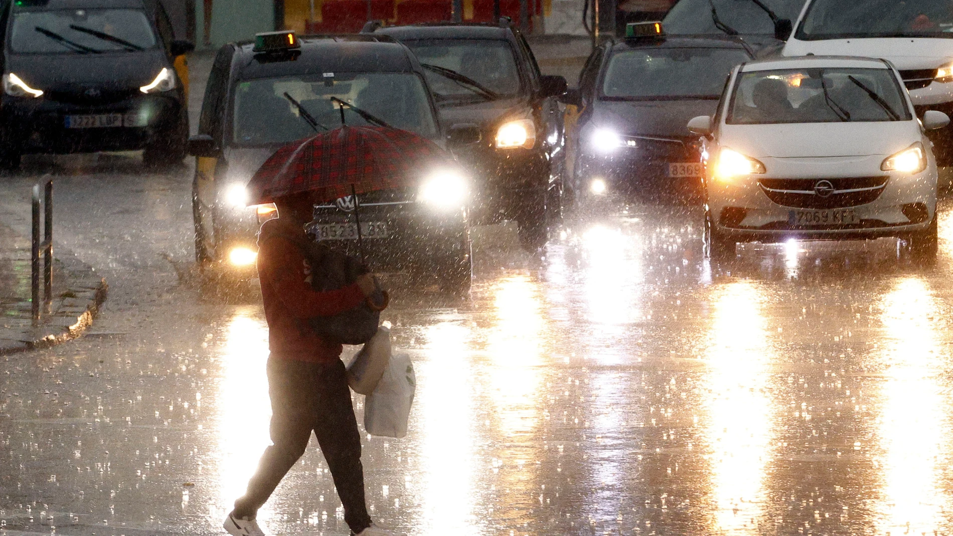 FOTODELDÍA GRAFCAT046. BARCELONA, 04/11/2024.- Una persona camina bajo un fuerte aguacero en la Plaza de Espanya de Barcelona este lunes cuando las comarcas de del Garraf y del Barcelonès, en Barcelona, están en aviso rojo de la Agencia Estatal de Meteorología (Aemet), y la Generalitat ha enviado una alerta a los teléfonos móviles por la llegada de lluvias continuadas y torrenciales. EFE/Quique García