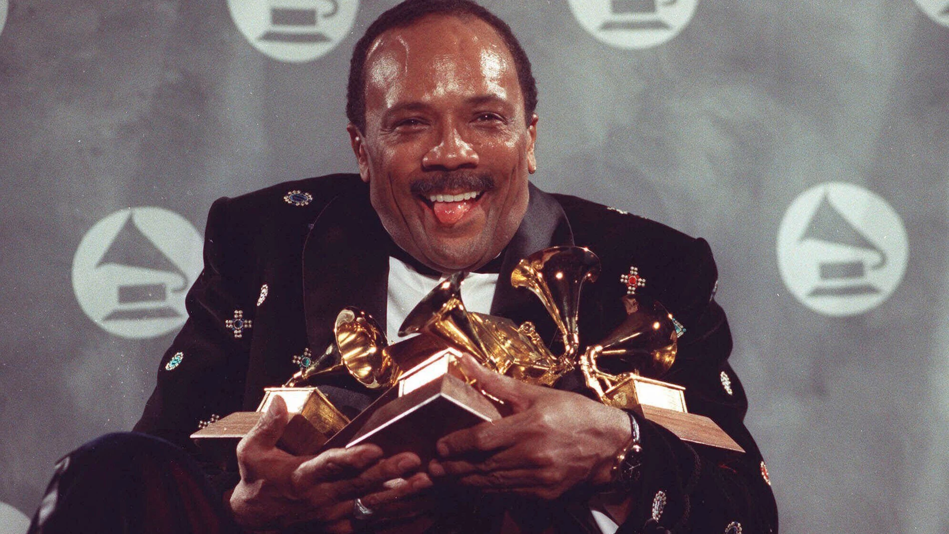 FILE - Quincy Jones cradles his Grammy awards including the album of the year award, for his eclectic album "Back on the Block" during the 33rd annual Grammy Awards, at New York's Radio City Music Hall night of Feb.20,1991. Quincy Jones died at age 91. (AP Photo/Susan Ragan, File)
