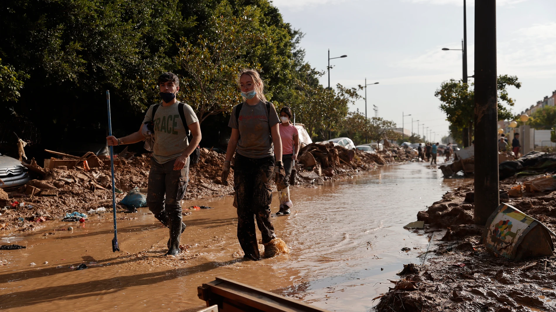 PAIPORTA (VALENCIA), 05/11/2024.- Varios voluntarios trabajan para despejar una calle de Paiporta (Valencia), este martes. Una semana después del paso de la dana, varios de los pueblos más afectados siguen "en shock" y con grandes necesidades, más allá de comida o productos de limpieza y desescombro, a pesar de la ayuda de los miles de voluntarios y el aumento de efectivos de la UME, ejército, bomberos y policías. EFE/ Manuel Bruque