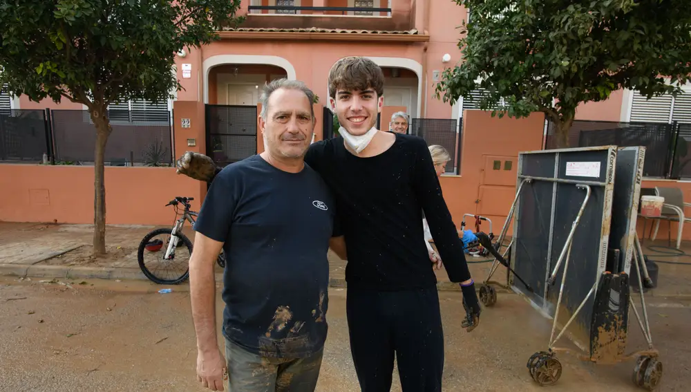 Benancio, junto a su vecino, ambos intentan todavía acabar de vaciar de agua sus garajes