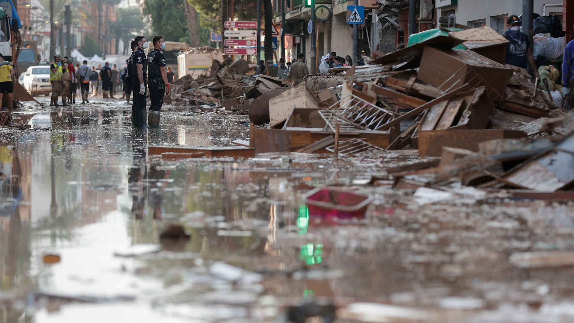 Efectivos de la Policía Local trabajan para despejar una calle de Paterna (Valencia), este martes. Una semana después del paso de la dana, varios de los pueblos más afectados siguen "en shock" y con grandes necesidades, más allá de comida o productos de limpieza y desescombro, a pesar de la ayuda de los miles de voluntarios y el aumento de efectivos de la UME, ejército, bomberos y policías. EFE/ Manuel Bruque