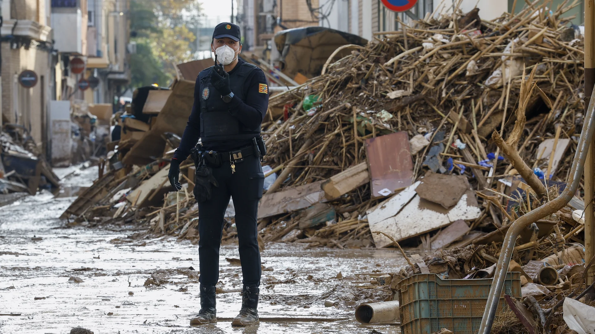 Un miembro de la Policía Nacional junto a una montaña de escombros en Catarroja, Valencia