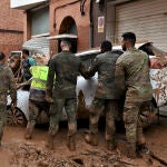 Efectivos del Ejército de Tierra retiran un vehículo para abrir la circulación de vehículos y personas en las calles de Aldaia y Algemesí