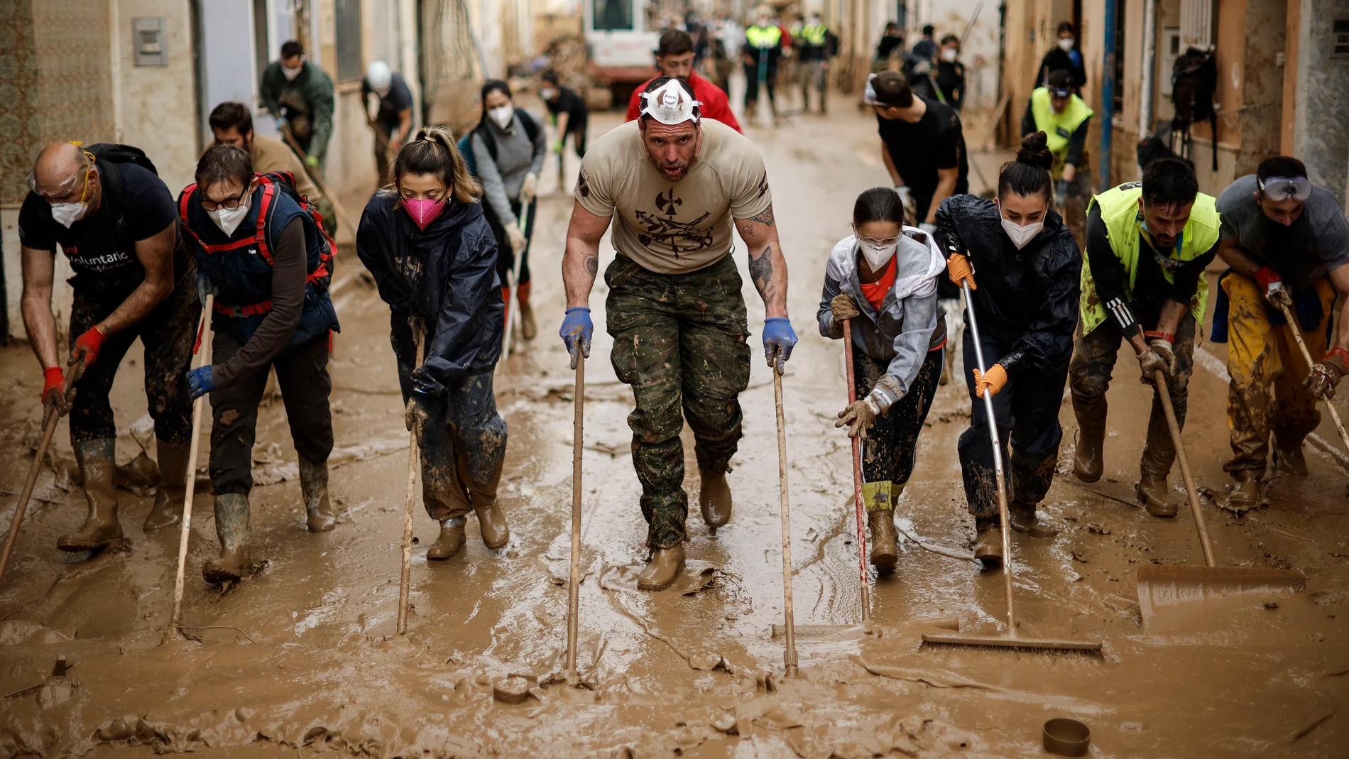 PAIPORTA (VALENCIA), 07/11/2024.- Voluntarios retiran lodo de una calle de Paiporta (Valencia) este jueves. Los pueblos de Valencia asolados por la dana afrontan el noveno día después de la catástrofe sumidos en un goteo incesante de llegada tanto de ayuda humanitaria como profesional y de maquinaria pesada, para intentar recuperar infraestructuras, colegios, zonas industriales y vías de comunicación mientras continúa la búsqueda de desaparecidos. EFE/ Biel Aliño