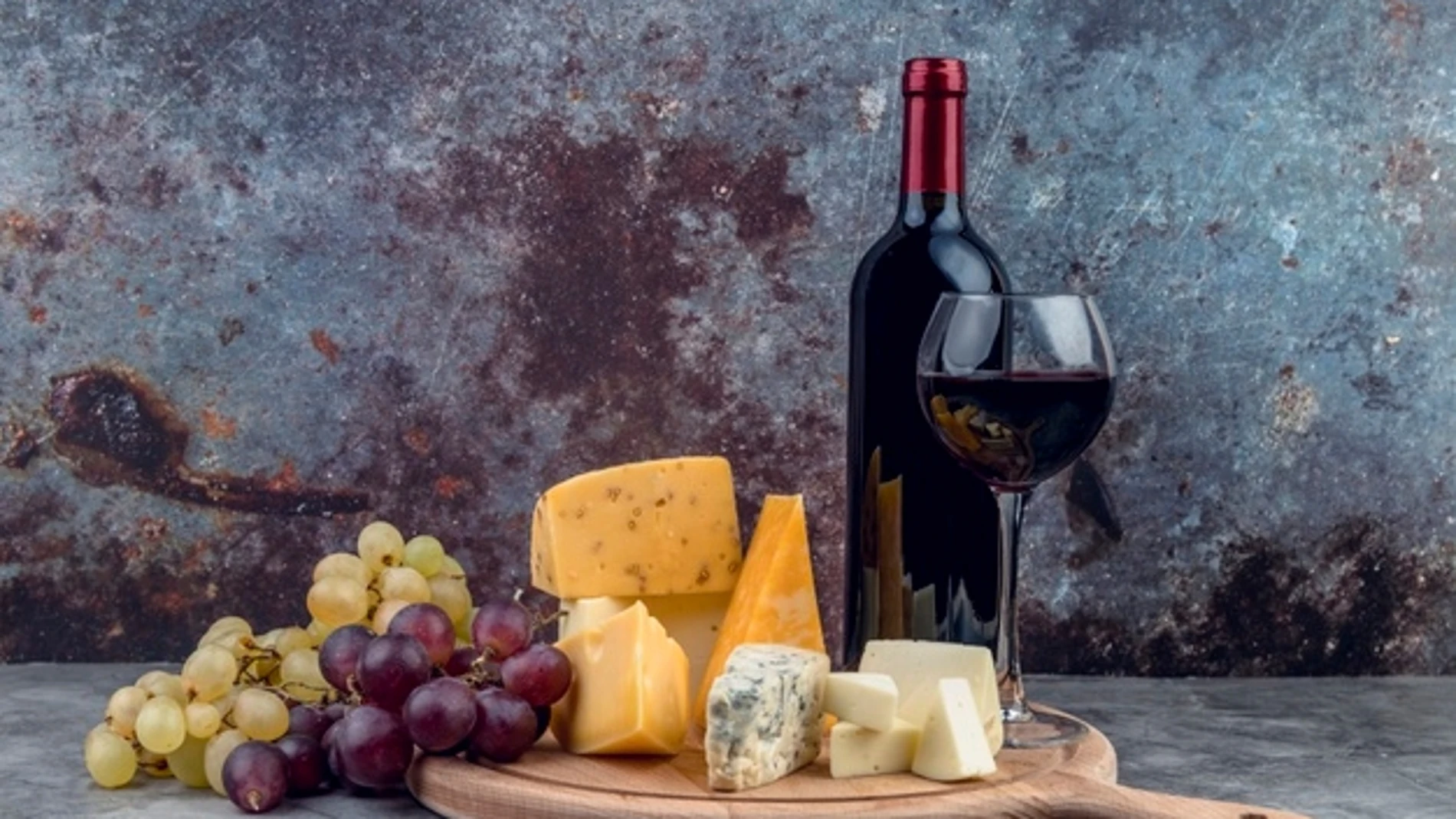 Imagen de una tabla de quesos manchegos junto a una botella de vino