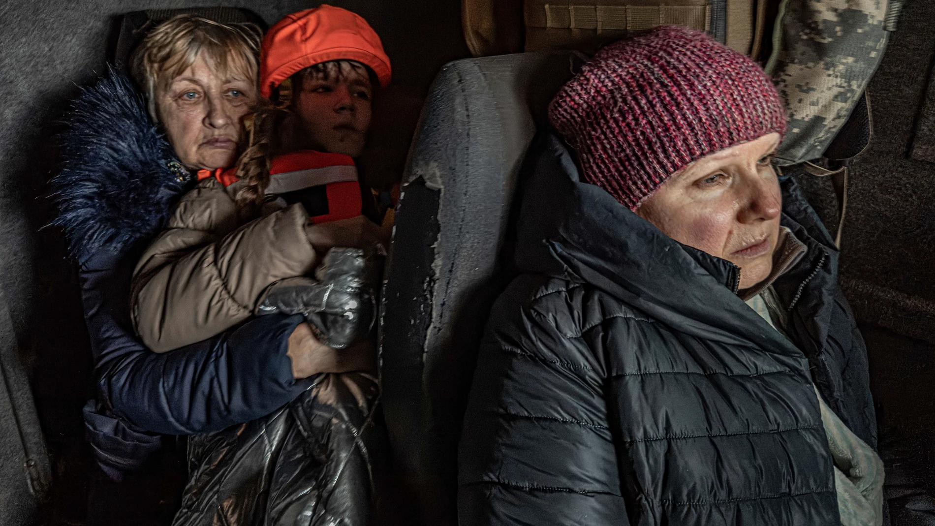 Katia, de 11 años, con su abuela y su madre sentadas en un monovolumen blindado durante una evacuación llevada a cabo por la unidad de policía «Ángeles Blancos» en Kurakhove, región de Donetsk, Ucrania, el 4 de noviembre de 2024.