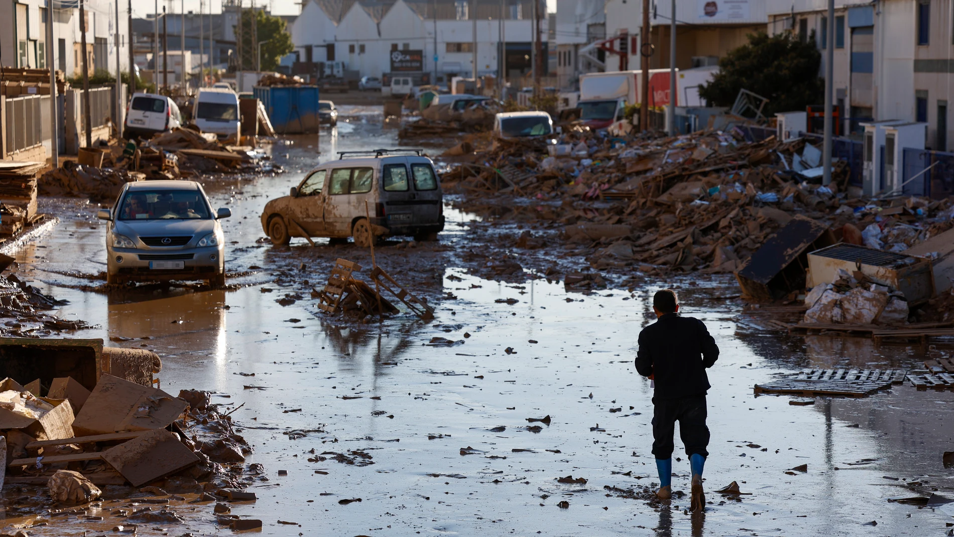 FOTODELDÍA CATARROJA (VALENCIA), 11/11/2024.- Una persona camina por una calle del polígono de Catarroja, este lunes. La última actualización de datos oficiales sobre los efectos de la dana y las devastadoras inundaciones del pasado 29 de octubre ha elevado a 222 el número de víctimas mortales confirmadas en toda España, y ha situado en 36.803 el número de personas que han sido rescatadas, 82 de ellas en las últimas horas. EFE/Jorge Zapata