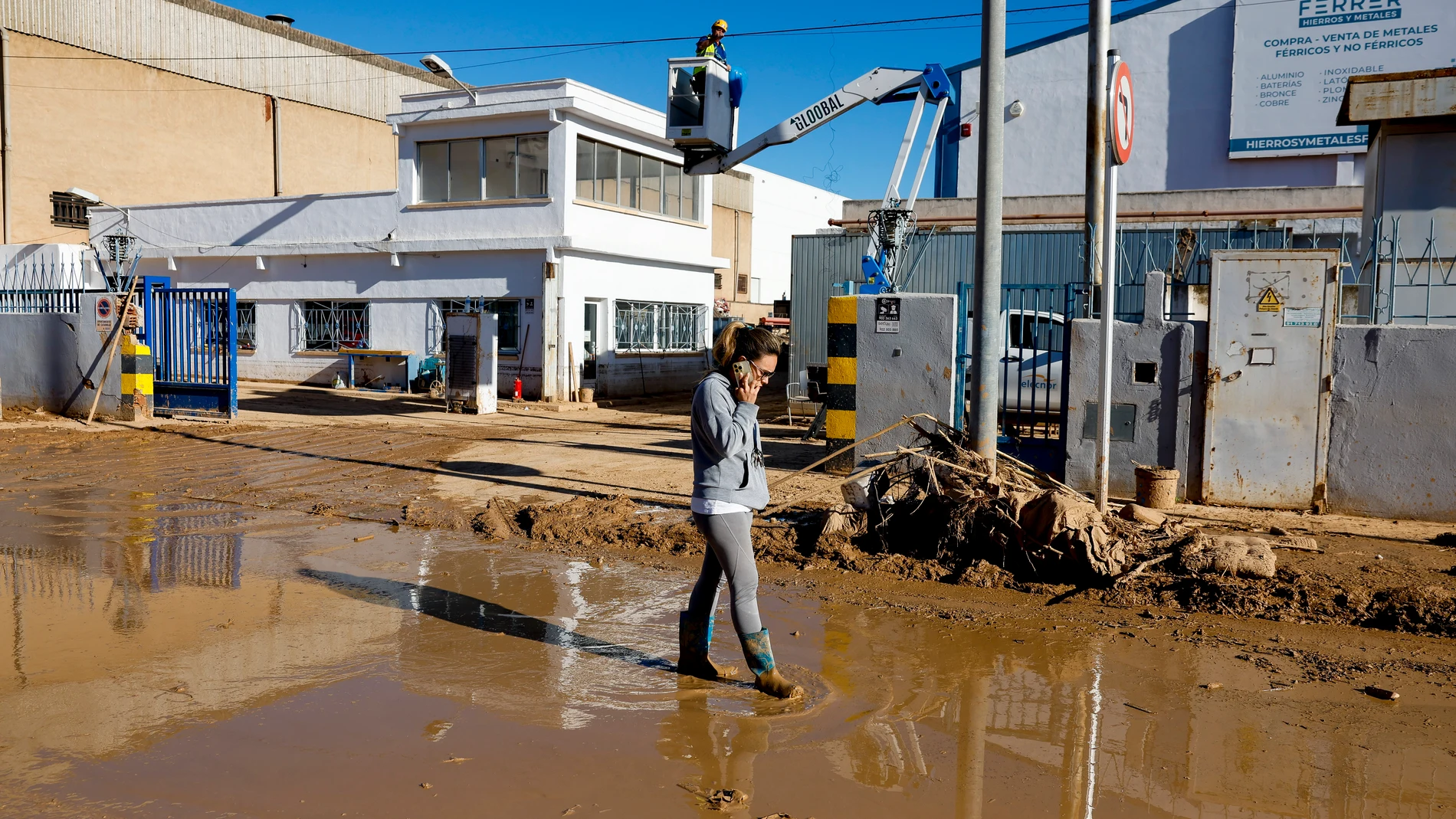 CATARROJA (VALENCIA), 11/11/2024.- Una mujer habla por teléfono en una calle anegada en el polígono de Catarroja, este lunes. La última actualización de datos oficiales sobre los efectos de la dana y las devastadoras inundaciones del pasado 29 de octubre ha elevado a 222 el número de víctimas mortales confirmadas en toda España, y ha situado en 36.803 el número de personas que han sido rescatadas, 82 de ellas en las últimas horas. EFE/Jorge Zapata