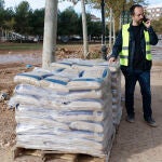  El alcalde de Aldaia, Guillermo Luján, conversa con por teléfono junto a varios palés de arena llevados a la localidad para proteger a las viviendas ante la posible llegada de una nueva dana anunciada a partir de este martes