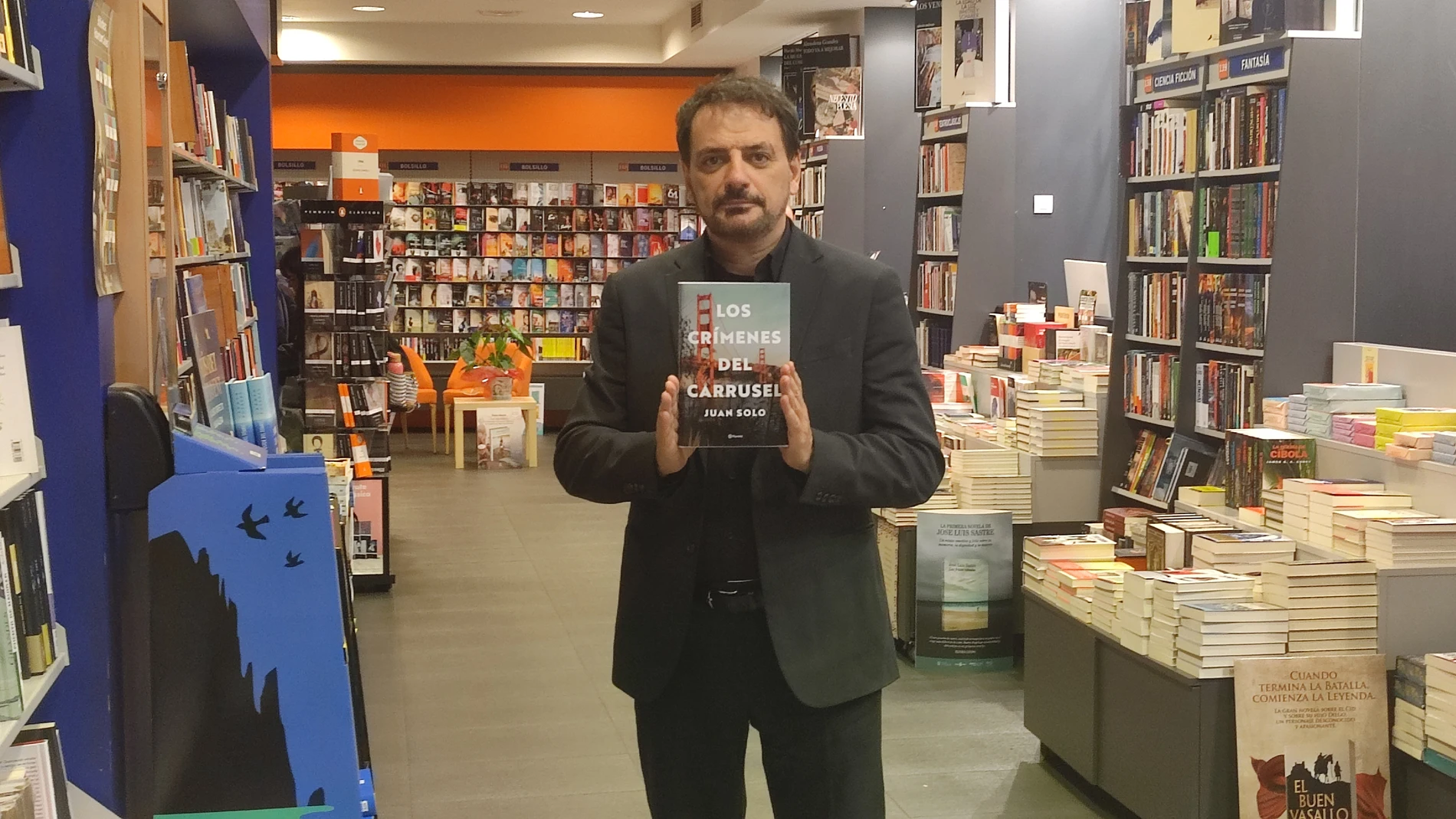 El escritor madrileño Juan Solo posa con su última novela "Los crímenes del carrusel" en la librería Oletvm de Valladolid