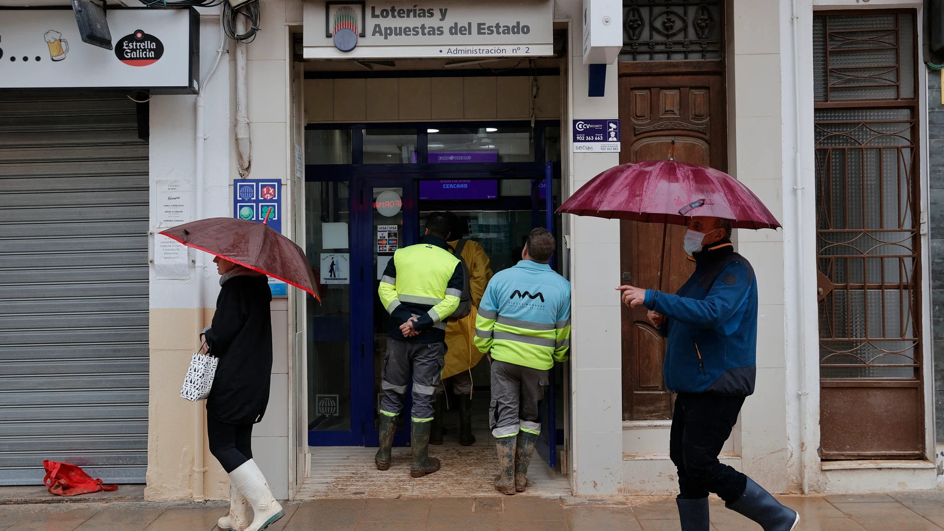 CATARROJA (VALENCIA), 13/11/2024.- Varias personas hacen cola en una administración de Lotería en Catarroja, este miércoles. Docenas de municipios de Valencia asolados por la dana afrontan, en medio del inédito despliegue de emergencia y ayuda solidaria, la amenaza de una nueva dana que ha obligado a suspender las clases y condiciona aún más el ingente trabajo para atender las innumerables llamadas de ayuda que emergen desde cada barrio, polígono o escuela, en muchos casos todavía cubiertos d...