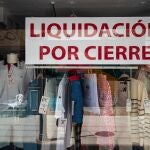 El escaparate de un comercio de ropa anuncia 'liquidación por cierre' en una calle de Palma de Mallorca.