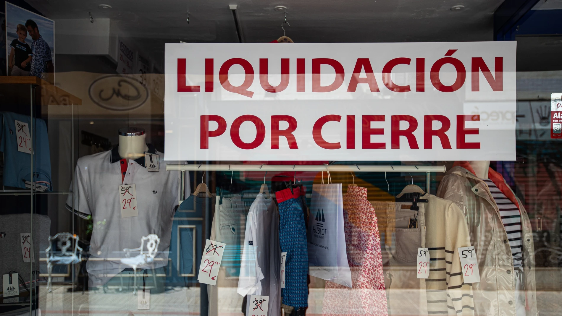 El escaparate de un comercio de ropa anuncia 'liquidación por cierre' en una calle de Palma de Mallorca.