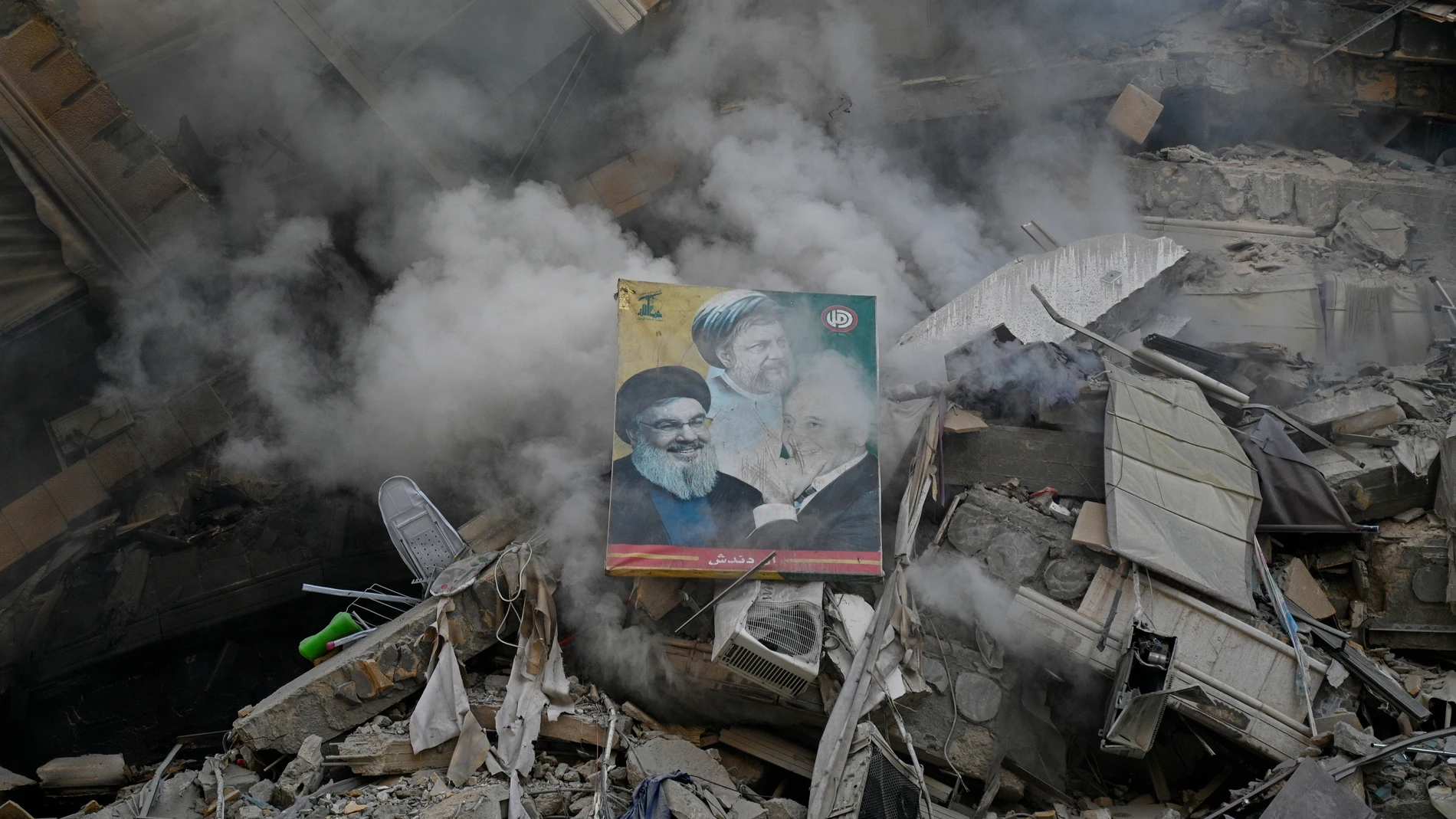 -FOTODELDÍA- Beirut (Líbano), 14/11/2024.- Una foto de Hassan Nasrallah (i), Nabih Berri (d) y Mousa Al-Sadr (c) entre los escombros tras un ataque aéreo israelí en la zona de Al-Chiyah, en el sur de Beirut, Líbano, el 14 de noviembre de 2024. Según el Ministerio de Salud libanés, alrededor de 3.365 personas han muerto y más de 14.344 han resultado heridas en el Líbano desde la escalada de hostilidades. entre Israel y Hezbolá. EFE/WAEL HAMZEH