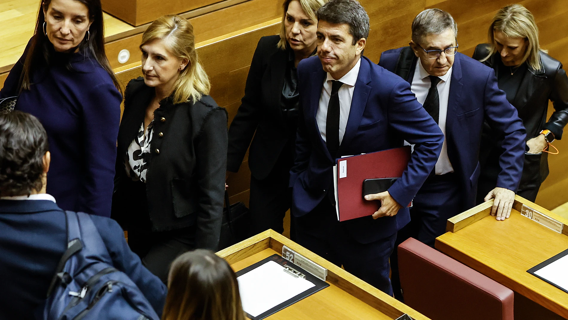 El presidente de la Generalitat Valenciana, Carlos Mazón (c), a su salida de una sesión plenaria, en Les Corts Valencianes, a 15 de noviembre de 2024, en Valencia, Comunidad Valenciana (España). Este es el primer pleno de Les Corts tras la DANA, que el pasado 29 de octubre arrasó Valencia, y ha comenzado con un minuto de silencio por las más de 200 víctimas mortales en la provincia. El presidente de la Generalitat, Carlos Mazón, ha dado explicaciones de su gestión durante el temporal y de cóm...