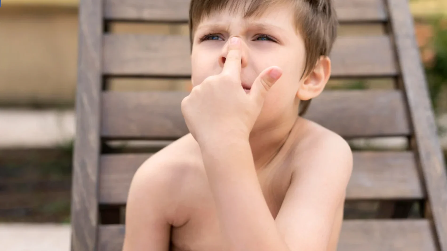 Un niño con el dedo en la nariz