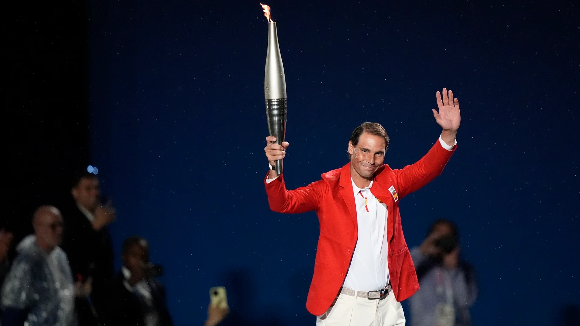 Torchbearer Rafael Nadal, of Spain, waves in Paris, France, during the opening ceremony of the 2024 Summer Olympics, Friday, July 26, 2024. (AP Photo/Frank Franklin II)