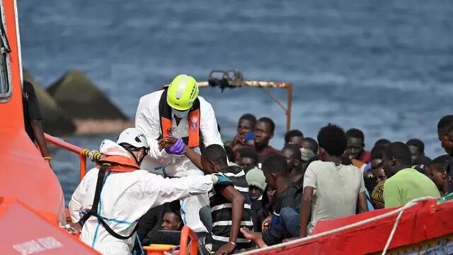 Trabajadores ayudan a los migrantes que llegan en patera al puerto de La Restinga, trasladados por Salvamento Marítimo, a 26 de julio de 2024, en El Hierro, Canarias