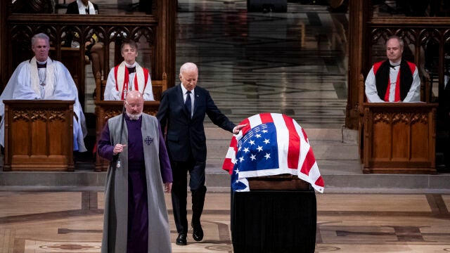 Joe Biden toca la bandera sobre el féretro de Jimmy Carter