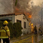 Los bomberos de Los Ángeles trabajando en una de las viviendas afectadas