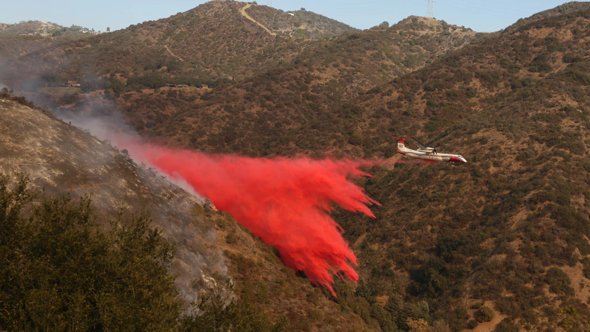 Los Angeles (United States), 11/01/2025.- A plane drops fire retardant against the Palisades wildfire in Los Angeles, California, USA, 11 January 2025. Thousands of firefighting and emergency personnel are involved in response efforts, as multiple wildfires are continuing to burn across thousands of acres in Southern California, destroying thousands of homes and forcing people to evacuate areas throughout the Los Angeles area. (incendio forestal) EFE/EPA/ALLISON DINNER
