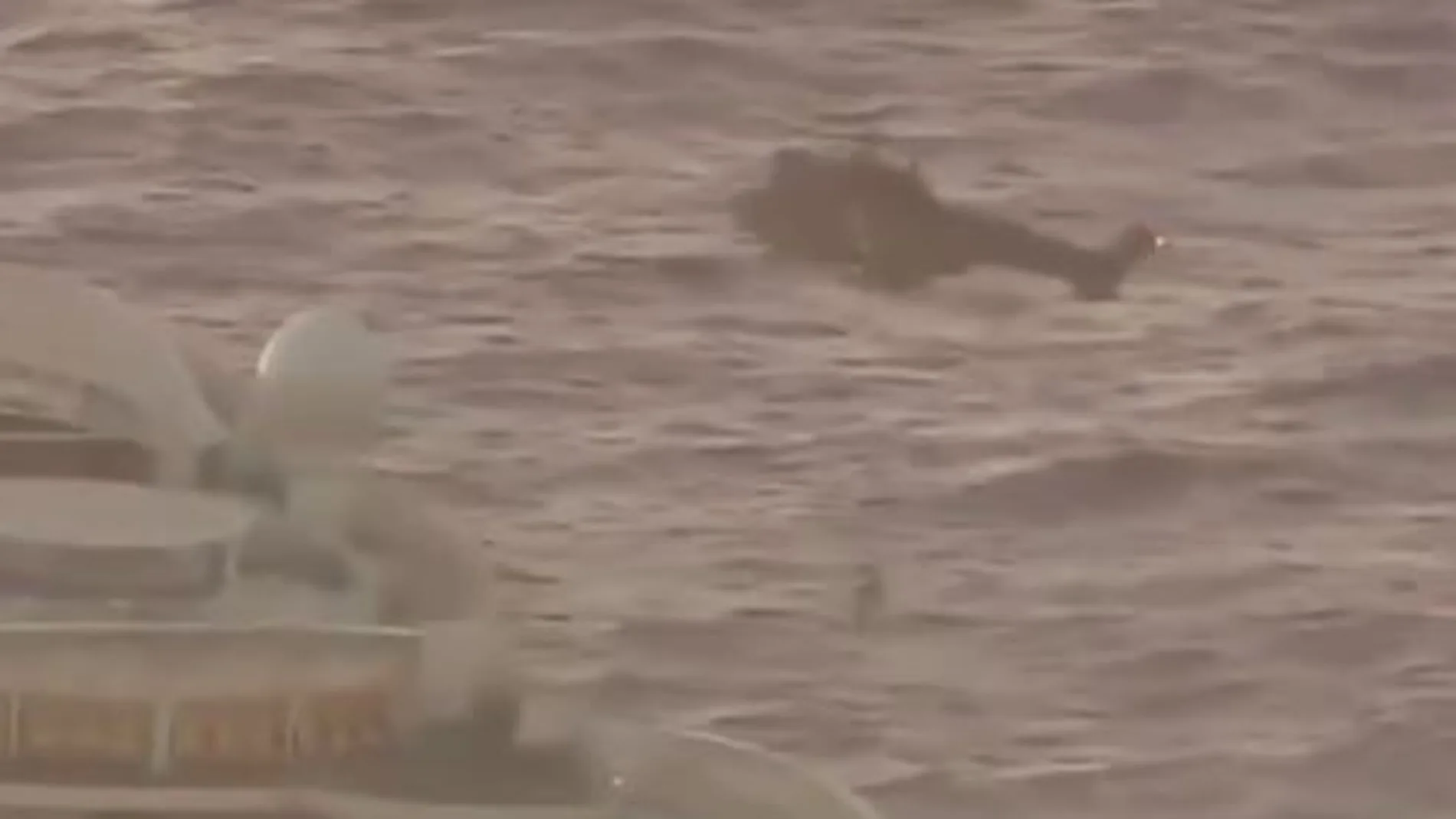 Momento en que el helicóptero iza a la pasajera enferma desde la cubierta del buque