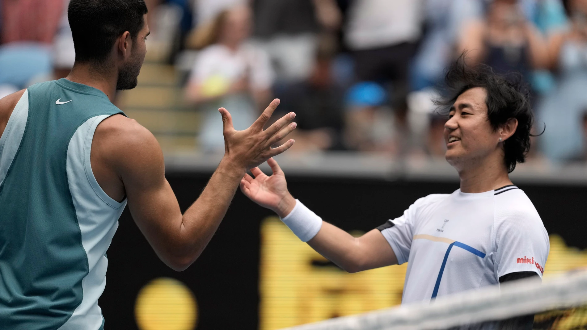 Carlos Alcaraz of Spain is congratulated by Yoshihito Nishioka, right, of Japan following their second round match at the Australian Open tennis championship in Melbourne, Australia, Wednesday, Jan. 15, 2025. (AP Photo/Ng Han Guan)