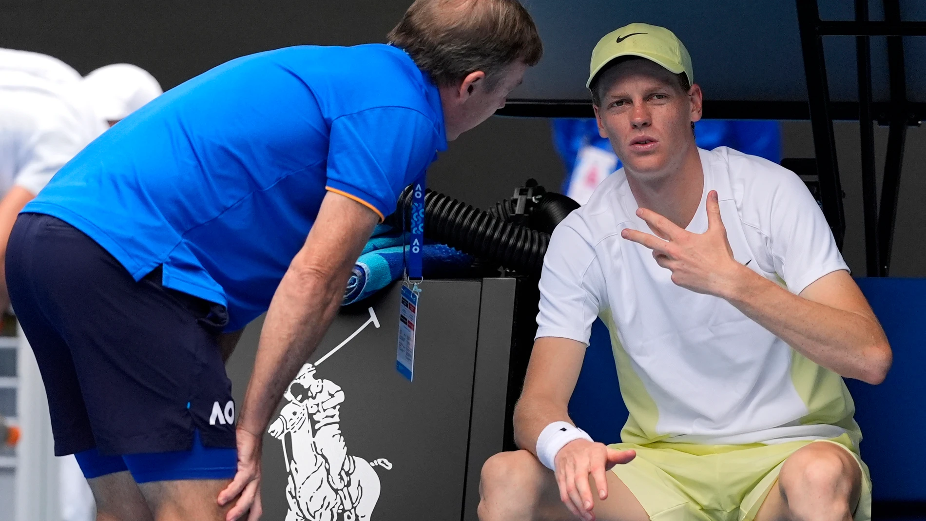 Jannik Sinner of Italy gestures as he talks with medical staff during his fourth round match against Holger Rune of Denmark at the Australian Open tennis championship in Melbourne, Australia, Monday, Jan. 20, 2025. (AP Photo/Asanka Brendon Ratnayake)