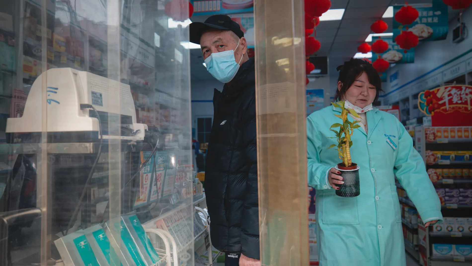 Un hombre con mascarilla en una farmacia de Wuhan