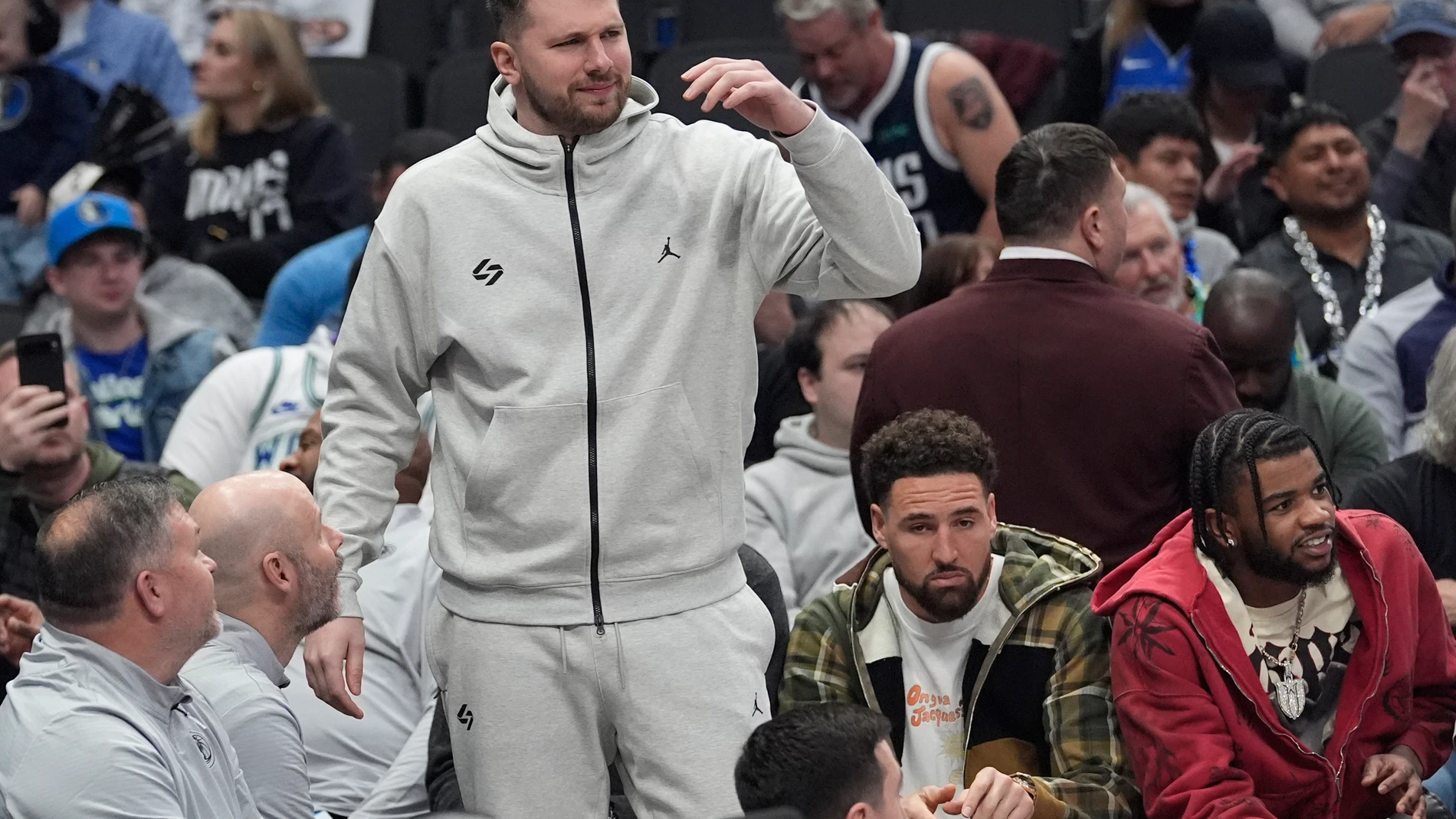 Injured Dallas Mavericks guards Luka Doncic, top center left, stands on the bench with teammates Klay Thompson, second from right, and Jaden Hardy, right, during the first half of an NBA basketball game against the Minnesota Timberwolves Wednesday, Jan. 22, 2025, in Dallas. (AP Photo/LM Otero)