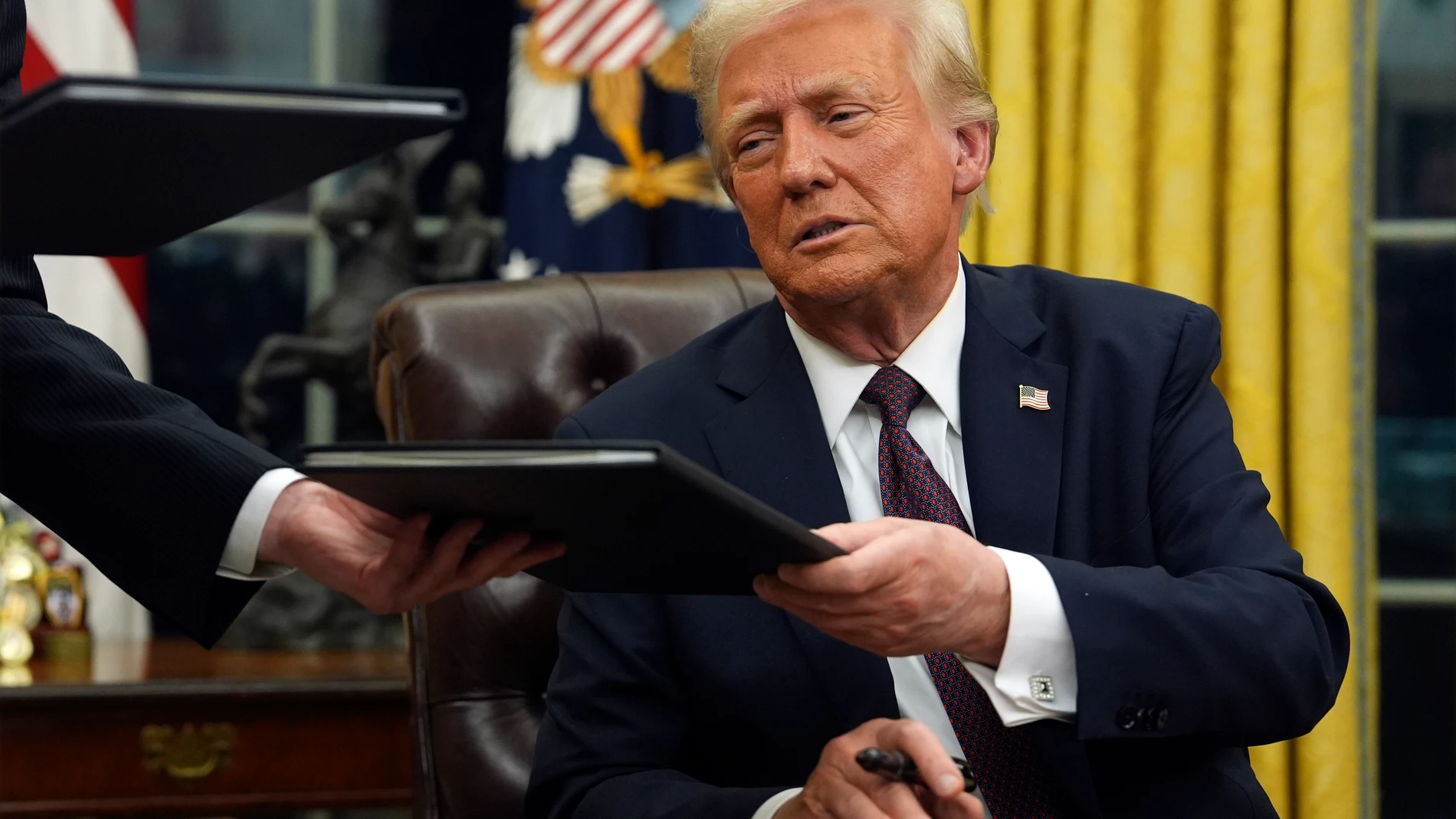 FILE - President Donald Trump signs executive orders in the Oval Office of the White House, Jan. 20, 2025, in Washington. (AP Photo/Evan Vucci, File)