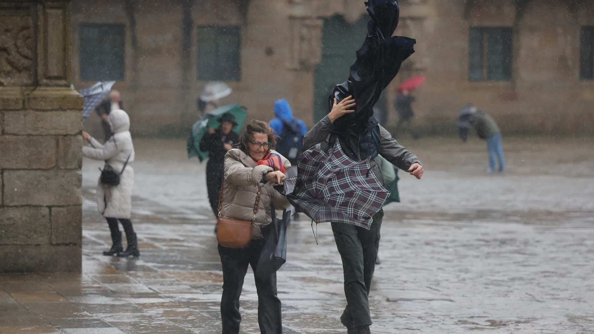SANTIAGO DE COMPOSTELA, 26/01/2025.- Turistas hoy domingo en la plaza del Obradoiro en Santiago de Compostela. Un potente temporal asociado a la borrasca Herminia va a azotar con fuerza a la península, con lluvias muy intensas y generalizadas, viento con rachas huracanadas por encima de los 20 kilómetros por hora en algunos puntos y aviso rojo en Galicia, donde las olas pueden alcanzar 10 metros de altura hoy en Santiago de Compostela. EFE/Lavandeira jr.