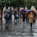Personas con paraguas caminan por Sevilla por las lluvias