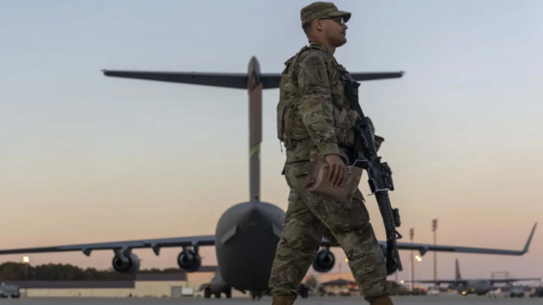 Miembros de la 82 División Aerotransportada del Ejército de los EE. UU. caminan sobre la pista en Pope Field antes del despliegue a Polonia desde Fort Bragg, en EEUU