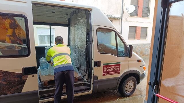 Un operario de la Diputación de Zamora descarga el agua embotellada en e municipio de Palacios del Pan 
