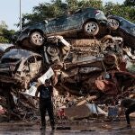 Varias personas limpian entre coches amontonados en Alfafar, a 5 de noviembre de 2024, en Valencia, Comunidad Valenciana (España). Hoy, se cumple una semana desde que la DANA arrasara la Comunitat Valenciana. Hasta el momento, hay 211 víctimas mortales y cuantiosos daños materiales en alrededor de 70 municipios de la provincia de Valencia, desde donde todavía hoy se siguen retirando enseres, vehículos y haciendo achiques de agua. Se ha restablecido ya el 98% del servicio eléctrico y el 93% de la población afectada ya dispone de suministro agua. Feria Valencia ha destinado siete pabellones, su Centro de Eventos y sus cocinas a diversas tareas logísticas y humanitarias para luchar contra los efectos de la DANA que ha afectado a la Comunitat Valenciana. 05 NOVIEMBRE 2024;DANA;RIADA;AFECTADOS;VALENCIA;COMUNIDAD VALENCIANA;DESTRUCCIÓN;ESCOMBROS;BASURA; Carlos Luján / Europa Press 05/11/2024