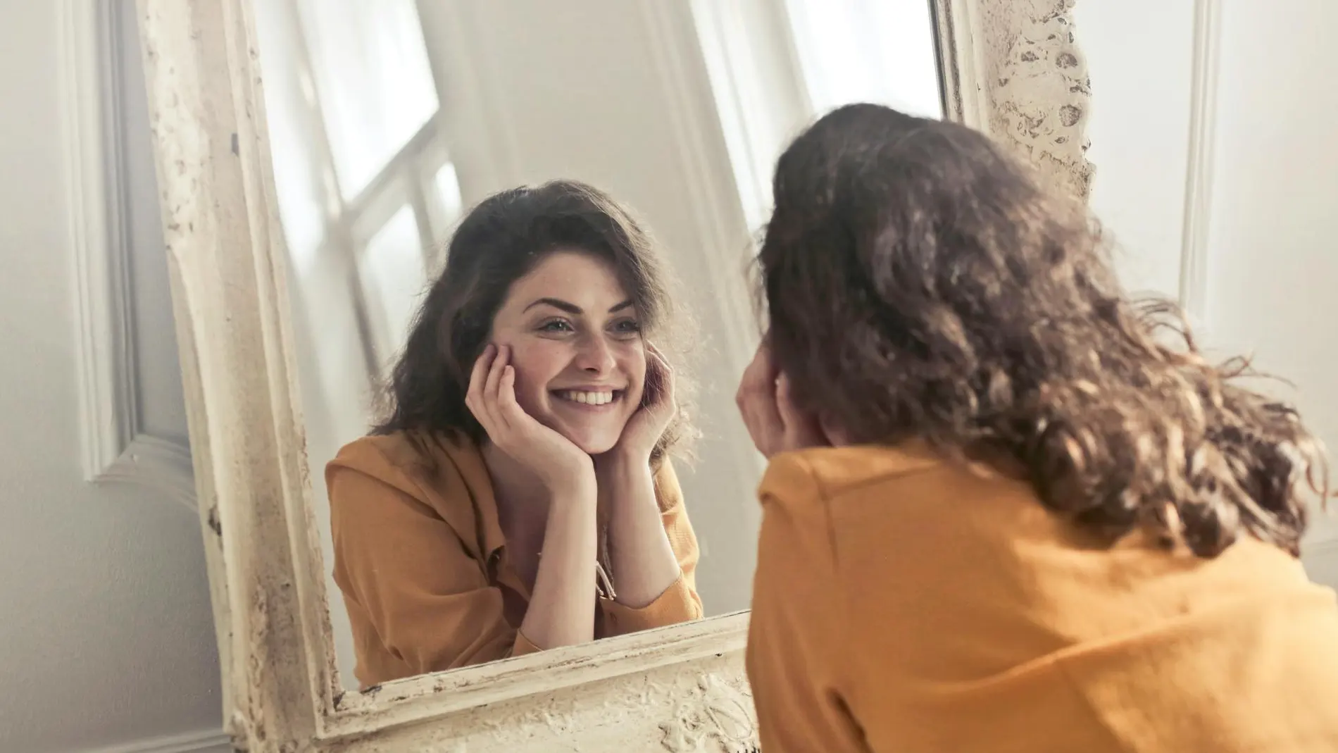 Mujer sonriendo al espejo