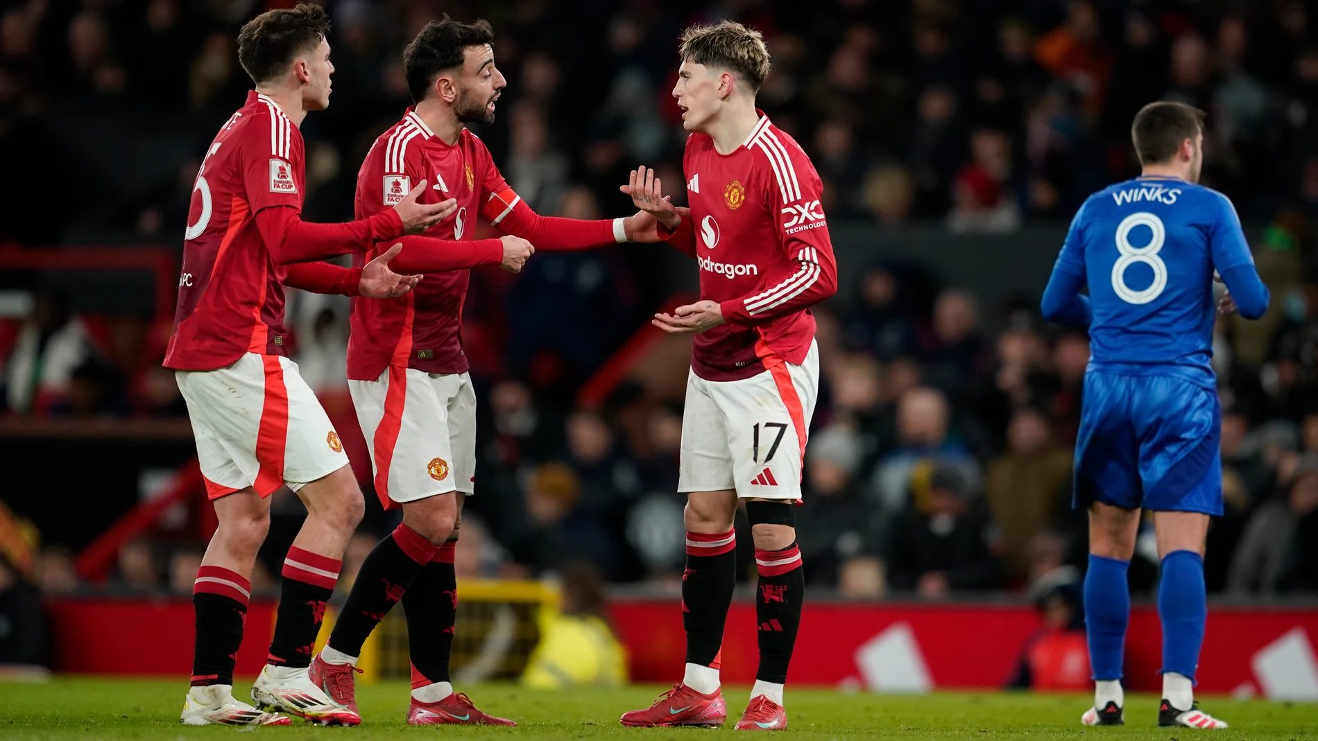 From left: Manchester United's Manuel Ugarte, Bruno Fernandes and Alejandro Garnacho talk during the English FA Cup fourth round soccer match between Manchester United and Leicester City at the Old Trafford stadium in Manchester, England, Friday, Feb. 7, 2025. (AP Photo/Dave Thompson)