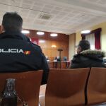 El acusado durante el juicio custodiado por agentes del CNP