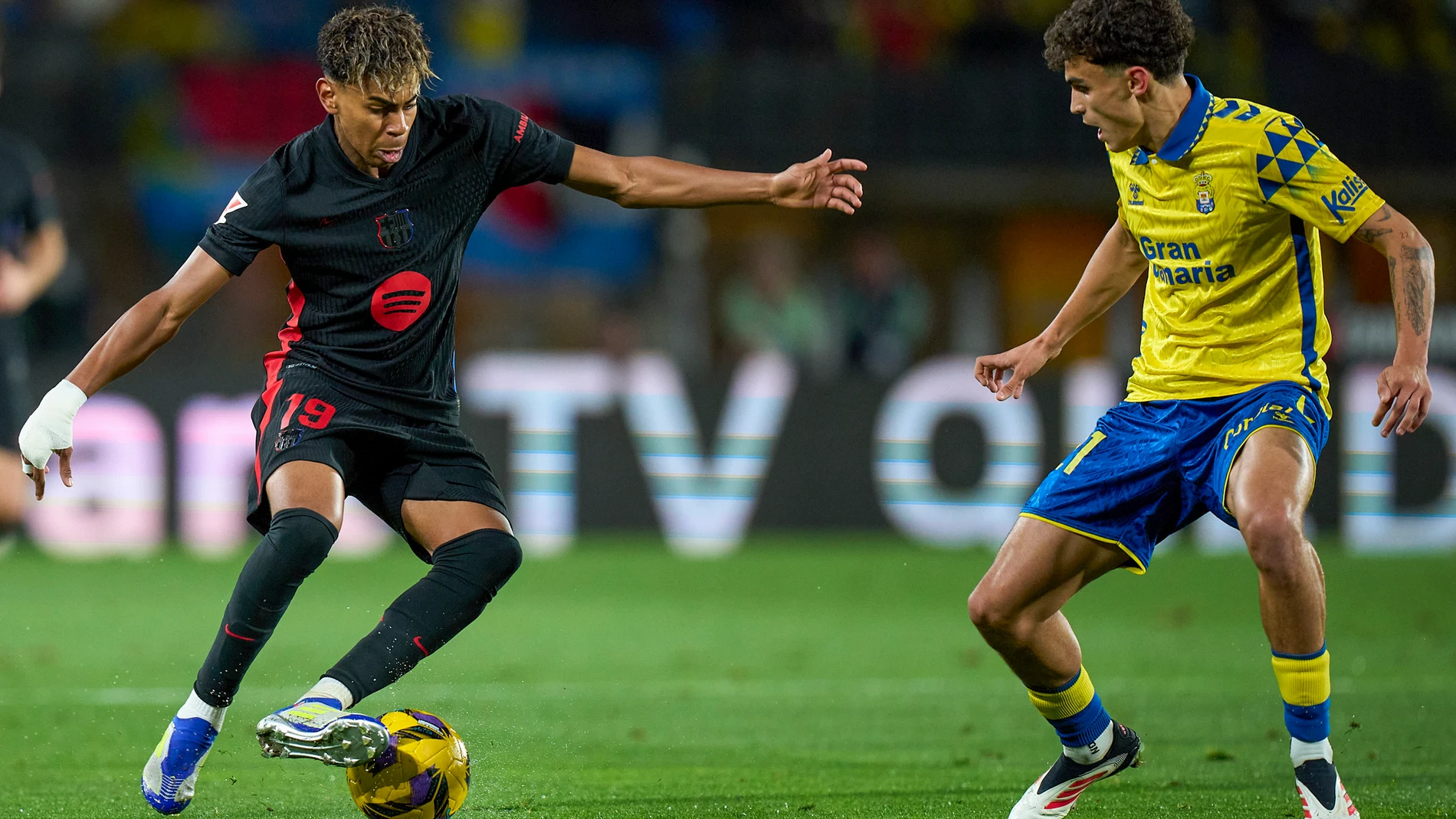 Barcelona's Lamine Yamal, left, duels for the ball with Las Palmas' Stefan Bajcetic during the Spanish La Liga soccer match between Las Palmas and Barcelona at the Gran Canaria stadium in Las Palmas, Spain's Canary Islands, Saturday, Feb. 22, 2024. (AP Photo/Gabriel Jimenez)