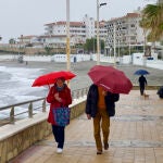 Una pareja camina por el paseo marítimo de la playa de la Torrecilla en Nerja