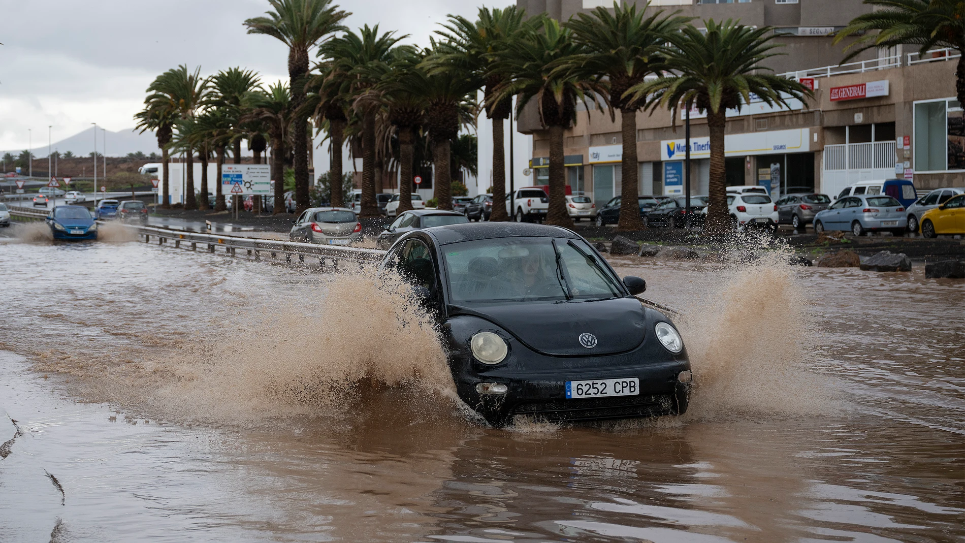 FOTODELDÍA GRAFCAN4398. ARRECIFE (LANZAROTE), 04/03/2025.- El Gobierno de Canarias mantiene este martes la prealerta por lluvias en toda Canarias. En la imagen, un coche atraviesa una zona anegada de agua en la entrada de Arrecife, en Lanzarote.EFE/ Adriel Perdomo