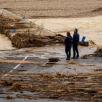 Dos personas contemplan el río Coves a su paso por Les Coves de Vinromà (Castellón)